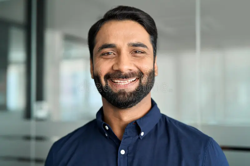 happy-indian-business-man-smiling-standing-office-headshot-face-portrait-bearded-leader-looking-camera-professional-297664234
